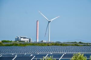 Coal power plant, wind turbines and solar panels in Sardinia; illustrative photograph