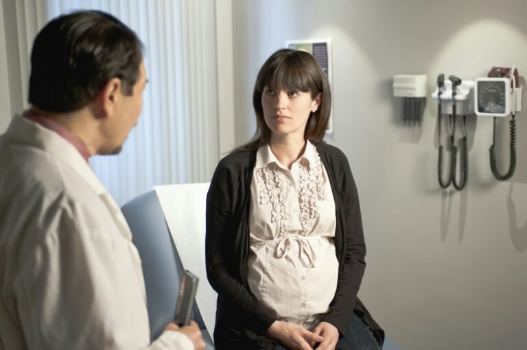 A doctor examines a pregnant patient — illustrative photograph, not taken in Barbados.