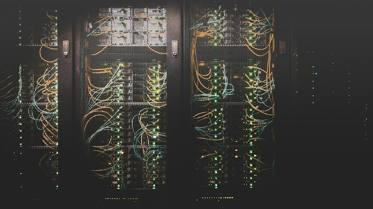 Сървърни шкафове с мрежови кабели — илюстративна снимка, не обект на Anthropic. / Server racks with network cables — illustrative photo, not an Anthropic facility.