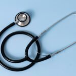 Стетоскоп върху син фон – илюстративна снимка / Stethoscope on a blue background – illustrative photo
