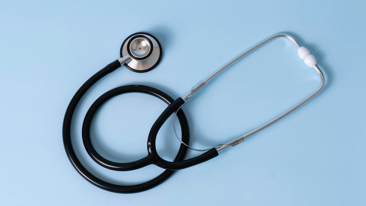 Стетоскоп върху син фон – илюстративна снимка / Stethoscope on a blue background – illustrative photo
