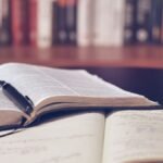 Отворени книги и записки върху бюро — илюстративна снимка за обучение