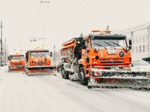 Three orange snowploughs on a snowy road; illustrative image, not taken in Gorna Oryahovitsa