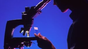 Специалист изследва препарат с микроскоп в лаборатория, илюстративна снимка