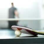 Ракета и бяла топка върху маса за тенис — илюстративна снимка, не от шампионата в Свищов