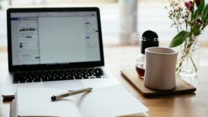 Лаптоп и тефтер върху работно бюро — илюстративна снимка